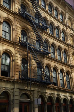 vintage building with fire escape stairs and arch windows in new york city, autumnal scene