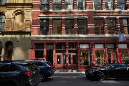 Téléchargez les photos : Bloc urbain avec des bâtiments anciens et la circulation se déplaçant sur la chaussée le jour de l'automne à New York - en image libre de droit