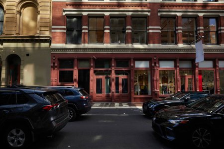 Téléchargez les photos : Quartier urbain avec des bâtiments anciens et des voitures se déplaçant sur la chaussée le jour de l'automne à New York - en image libre de droit