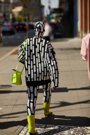 Téléchargez les photos : NEW YORK, États-Unis - 26 NOVEMBRE 2022 : Vue de l'arrière d'une personne extravagante à la mode marchant le long de la rue dans la ville de New York, style urbain - en image libre de droit