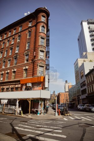 red brick building with store under reconstruction on crossroad in chinatown of new york city
