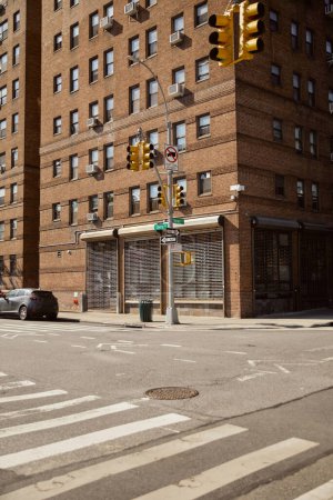 red brick building with storefront of closed shop on crossroad with traffic light in new york