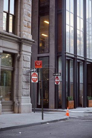 contemporary buildings and different road signs on avenue in new york city, metropolis streetscape