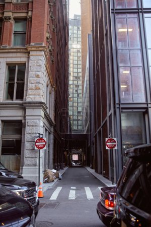 Autos, die in der Nähe geparkt werden, fahren nicht in Straßenschilder zwischen modernen Gebäuden an der Stadtstraße in New York City