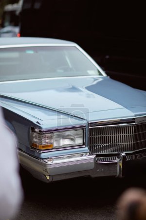 Photo for Luxury vintage car parked on roadway in new york city, urban environment, blurred foreground - Royalty Free Image