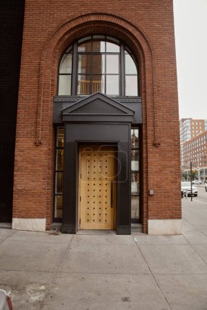 entrance of brick building with portico and arch window in downtown of new york, urban architecture