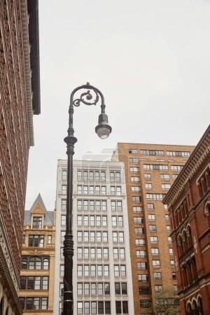 Photo for Low angle view of decorated lantern near contemporary buildings in new york city, urban architecture - Royalty Free Image