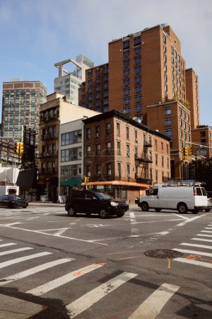Téléchargez les photos : Voitures se déplaçant à l'intersection de la circulation avec passage piétonnier sur l'avenue large dans le centre-ville de New York - en image libre de droit