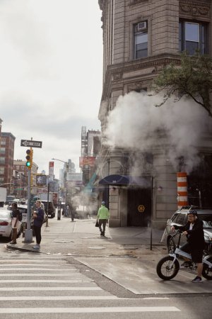 Photo for NEW YORK, USA - NOVEMBER 26, 2022: pedestrian crossing on avenue with steam, metropolis scene - Royalty Free Image