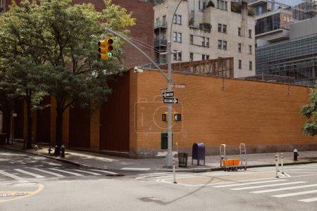 murowany płot przy biegunie drogowym ze światłem skrzyżowania z przejściem dla pieszych w Nowym Jorku
