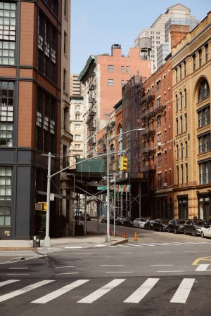 new york street with modern and vintage buildings near traffic intersection with pedestrian crossing