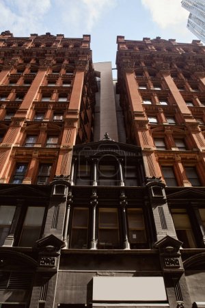 vintage stone building in downtown of new york city, metropolis architecture, low angle view
