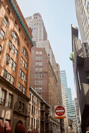 Photo for Do not enter sign on avenue with modern and vintage buildings in new york city, urban streetscape - Royalty Free Image