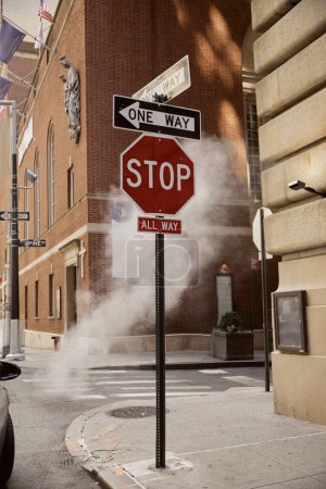 señales de tráfico cerca de vapor y edificios antiguos en el centro de la ciudad de Nueva York, el medio ambiente metrópolis