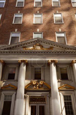 entrance of brick building with columns and portico, vintage architecture of new york city