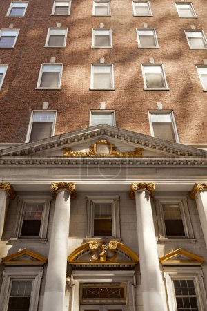 vintage architecture of new york city, low angle view of brick building with columns and portico