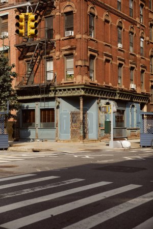 Foto de Edificio de época con escalera de incendios cerca de paso peatonal en la ciudad de Nueva York, escena urbana - Imagen libre de derechos
