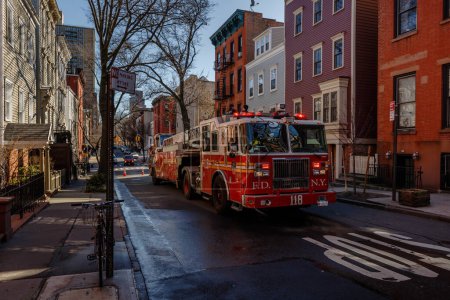 Téléchargez les photos : Brooklyn, New York, USA - 11 février 2023 : FDNY Hook and Ladder 118 en formation près de la porte de garage de la caserne de pompiers Engine 205 H & L 118 à Brooklyn près de Manhattan un jour d'hiver - en image libre de droit