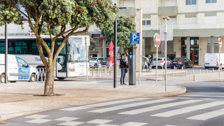Téléchargez les photos : Povoa de Varzim, Porto, Portugal - 22 octobre 2020 : Une femme achète un ticket de parking à partir d'un guichet automatique sur le trottoir du bord de mer un jour d'automne - en image libre de droit