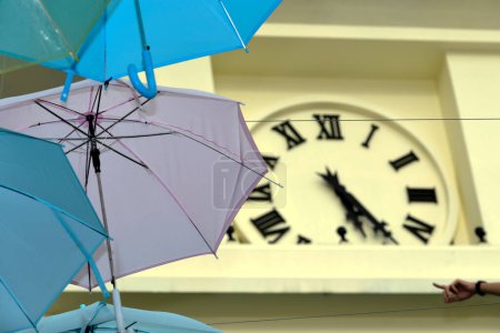 Téléchargez les photos : Parapluie coloré avec tour d'horloge floue en arrière-plan - en image libre de droit