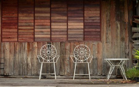 Téléchargez les photos : Chaise et table blanche antique avec mur en bois brun rouge d'une maison - en image libre de droit