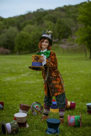 Téléchargez les photos : Belle femme comme chapelier fou avec des chapeaux dans la nature - en image libre de droit