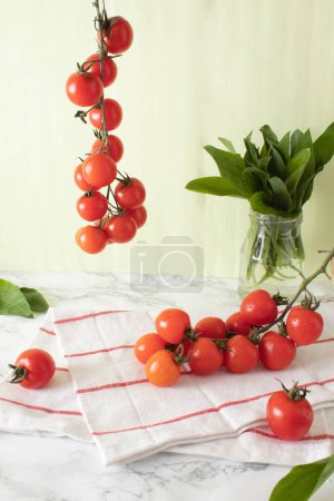 Ramsons and cherry tomatoes on marble work surface in a kitchen. Healthy food concept