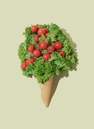 Photo for Ice cream cone with lettuce and cherry tomatoes on bright background. Flat lay. Nature summer concept. - Royalty Free Image