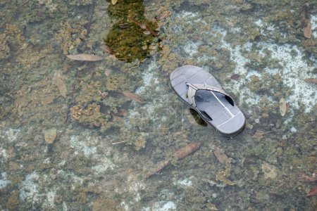 Foto de Lampung, November 2022 -  flip-flops left in the water can describe evidence and clues to a crime - Imagen libre de derechos