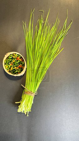 Photo for Chinese chives or garlic chives, along with chiltepin chili. Ingredients for the preparation of chiltepin chilli sauce - Royalty Free Image