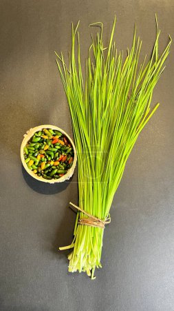 Photo for Chinese chives or garlic chives, along with chiltepin chili. Ingredients for the preparation of chiltepin chilli sauce - Royalty Free Image