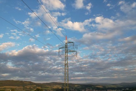 Photo for Aerial view high voltage steel power pylons in field in the countryside. Misty morning, dawn. Drone flight low over power transmission lines. Electric tower line, sunrise sunset,power lines network - Royalty Free Image