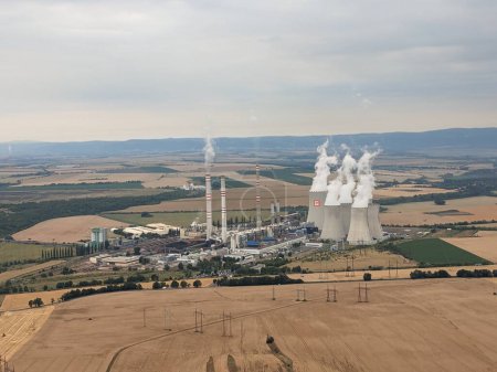 Foto de Pocerady, Czech republic - June 28 2023: Aerial panorama view of Pocerady coal power plant with smokestacks and cooling towers in the middle of nothern Bohemian landscape.Huge energy sources - Imagen libre de derechos