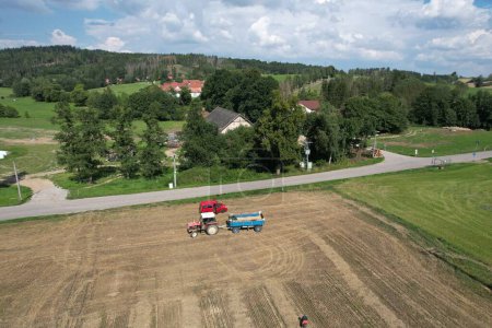 Photo for Combine harvester Fortschritt E 512 aerial panorama of czech small agriculture farm during harvest time with old harvestor in the yeallow fields in Vysocina region,Czech republic,Europe - Royalty Free Image