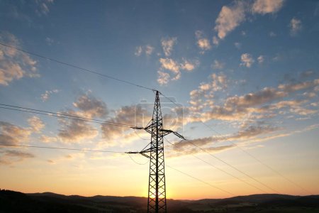 Photo for Aerial view high voltage steel power pylons in field in the countryside. Misty morning, dawn. Drone flight low over power transmission lines. Electric tower line, sunrise sunset,power lines network - Royalty Free Image