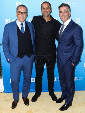 Photo for Co-Founder, Chairman and CEO of Republic Records Monte Lipman, American singer-songwriter Jack Johnson and Co-Founder, President and COO of Republic Records Avery Lipman arrive at the City Of Hope's 2022 Spirit Of Life Gala held at the Pacific Design - Royalty Free Image
