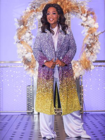Foto de Oprah Winfrey, presentadora de programas de entrevistas, productora de televisión, actriz, autora y propietaria de medios de comunicación estadounidense, con un abrigo de Oscar de la Renta, asiste como Oprah Winfrey y el elenco de Warner Bros. 'The Color Purple' Light The Empire State Building PURPLE - Imagen libre de derechos