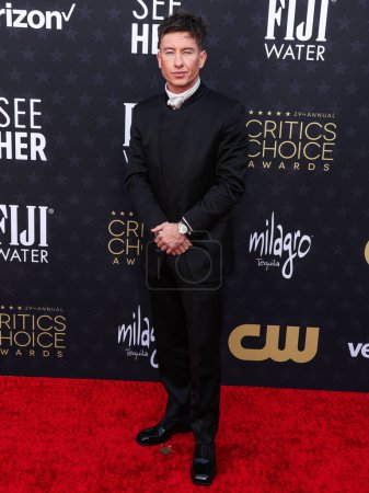 Photo for Barry Keoghan wearing a Zegna suit, Christian Louboutin shoes, and an Omega watch arrives at the 29th Annual Critics' Choice Awards held at The Barker Hangar on January 14, 2024 in Santa Monica, Los Angeles, California, United States. - Royalty Free Image