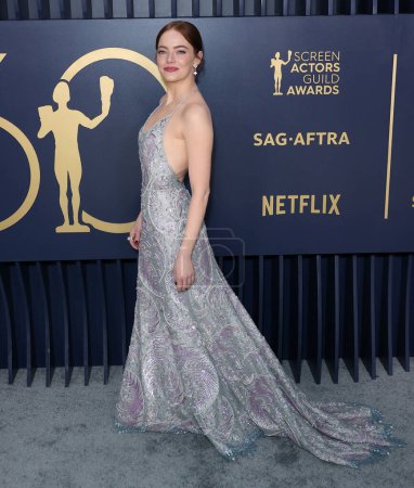 Photo for Emma Stone wearing a Louis Vuitton metallic lace slip gown, embroidered with sequins, pearls and crystals fern leaf pattern and ivory sandals with Louis Vuitton High Jewelry arrives at the 30th Annual Screen Actors Guild Awards - Royalty Free Image
