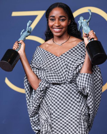 Photo for Ayo Edebiri, winner of the Outstanding Performance by a Female Actor in a Comedy Series and Outstanding Performance in a Comedy Series award for 'The Bear' poses in the press room at the 30th Screen Actors Guild Awards in February 24, 2024 in LA, USA - Royalty Free Image
