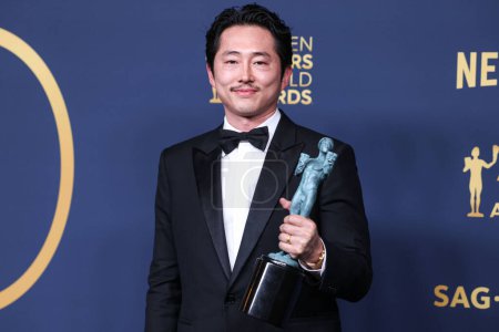 Photo for Steven Yeun, winner of the Outstanding Male Actor in a Television Movie or Limited Series award for 'Beef' poses in the press room at the 30th Screen Actors Guild Awards held at the Shrine Auditorium and Expo Hall on February 24, 2024 in LA, USA. - Royalty Free Image
