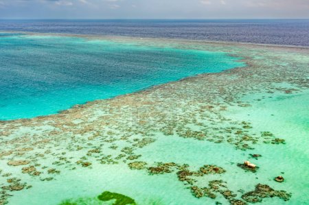 Panoramic vista from Sanganeb Lighthouse reveals a stunning coral reef lagoon in Sudans Red Sea. Natures vibrant underwater world awaits exploration.