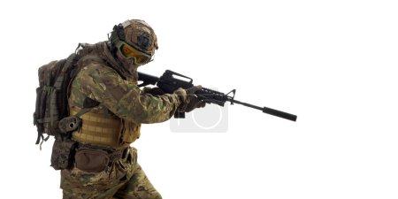 Téléchargez les photos : Soldier with an automatic rifle looking back controlling his sector of fire during the withdrawal of his group. Professional special forces fighter during a special operation. - en image libre de droit
