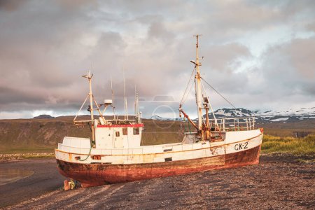 Photo for Abandoned vessel stranded on a beach on the Icelandic coast in the light of the midnight sun - Royalty Free Image