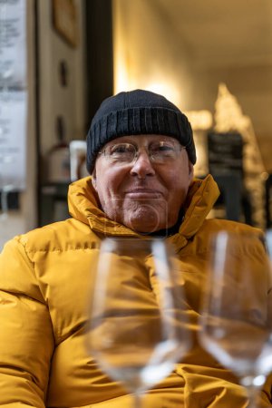 Foto de Elegant mature man toasting with white wine sitting in outdoor cafe in winter - Imagen libre de derechos