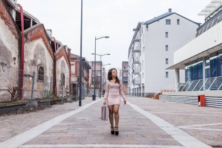 Foto de Young pretty businesswoman walking in an avenue on the outskirts of a big city - Imagen libre de derechos