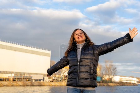 Photo for Middle aged woman wearing winter clothes taking fun by a river - people in recreation concept - Royalty Free Image