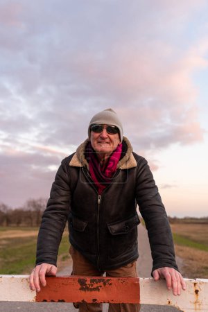 Téléchargez les photos : Middle aged man wearing winter clothes taking a break in a country road - concept of people in recreation - en image libre de droit