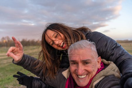 Photo for Middle aged couple wearing winter clothes taking a selfie in the countryside - concept of people in recreation - Royalty Free Image