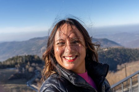 Téléchargez les photos : Femme d'âge moyen portant des vêtements d'hiver prendre un selfie sur une montagne - concept de personnes en vacances - en image libre de droit